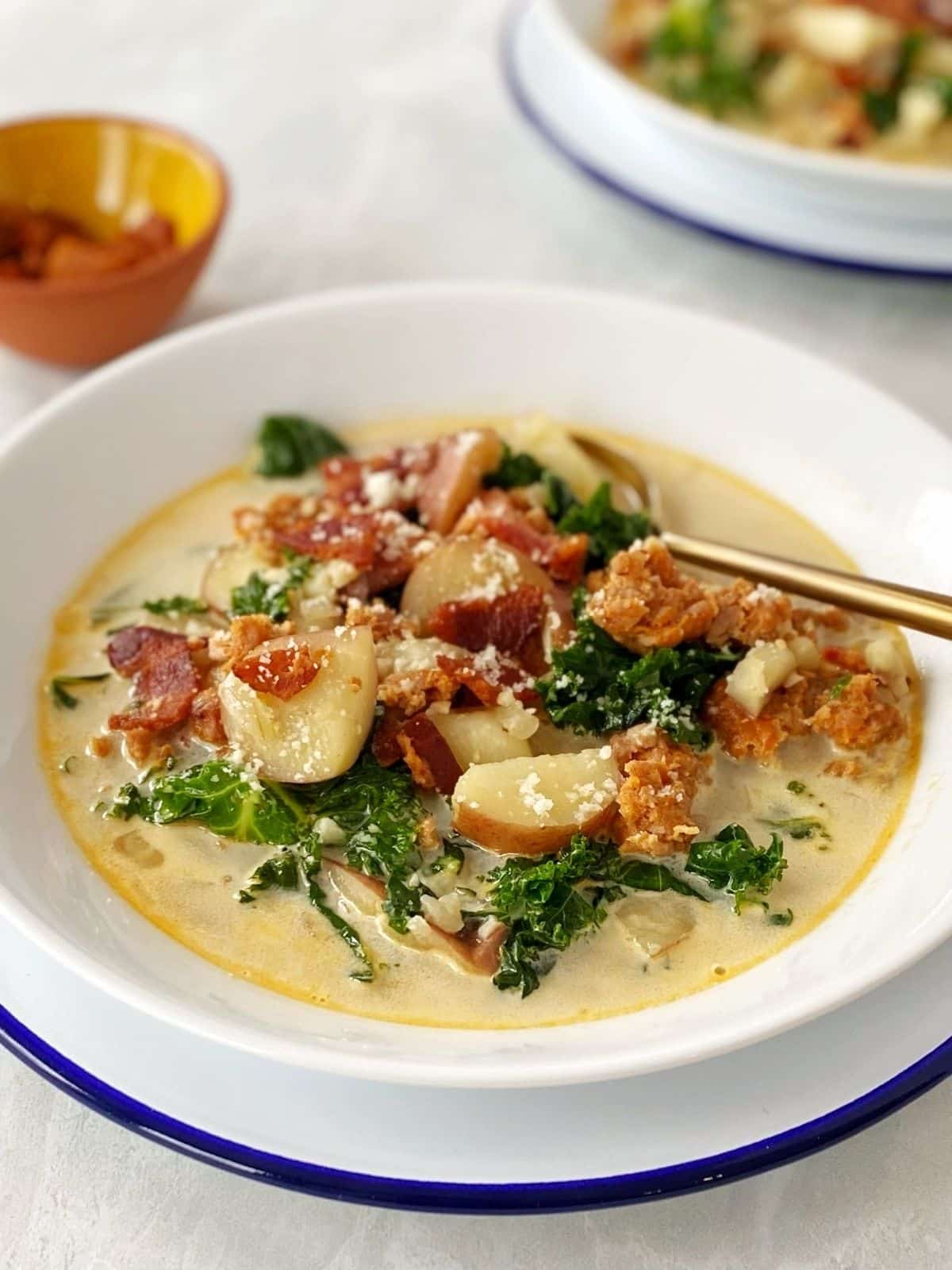 bowl of kale and potato soup garnished with bacon and Parmesan