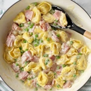 top down close up of tortellini and ham in skillet.
