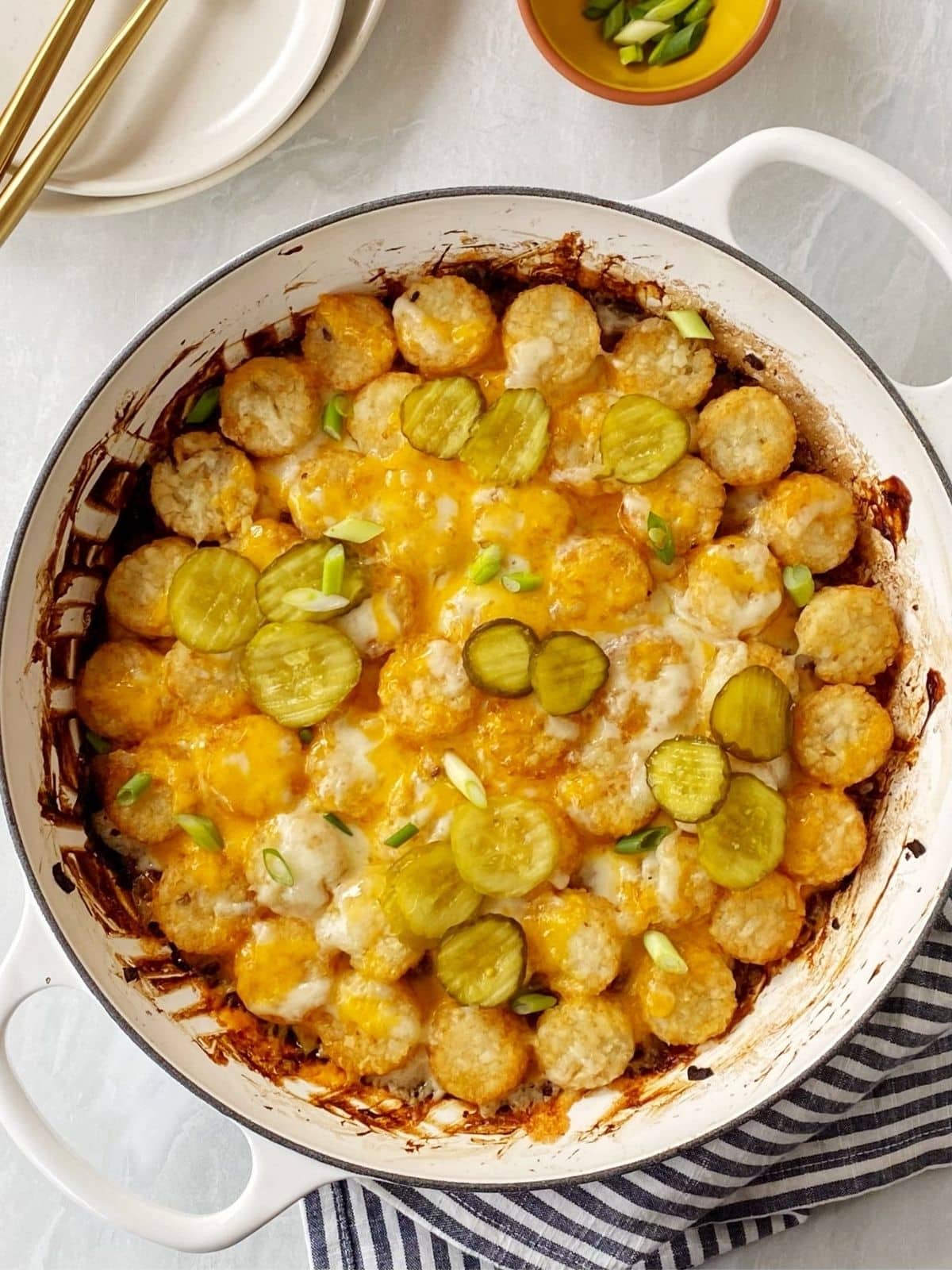 skillet casserole garnished with pickles and scallions.
