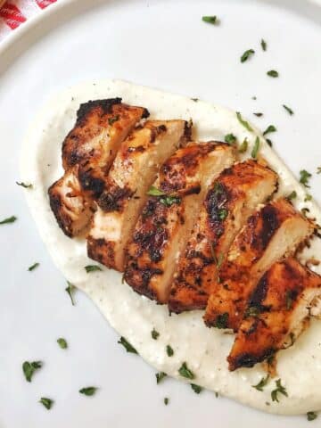 sliced chicken with blue cheese sauce on white plate.