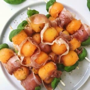 prosciutto melon skewers on a plate.