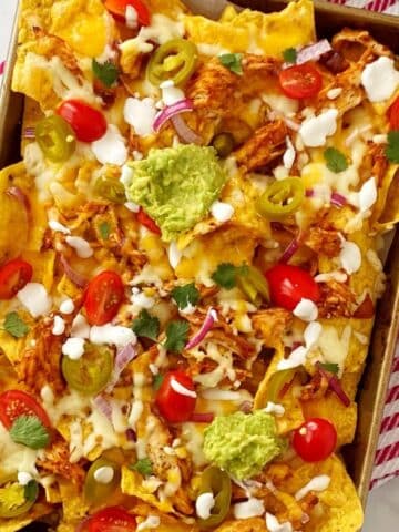 top down shot of nachos topped with garnishes.