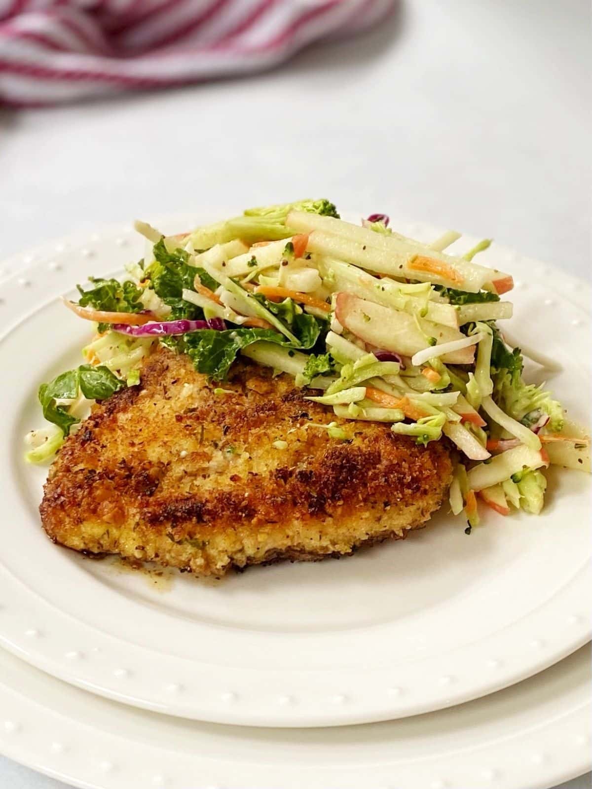 chicken cutlet topped with slaw on a plate.