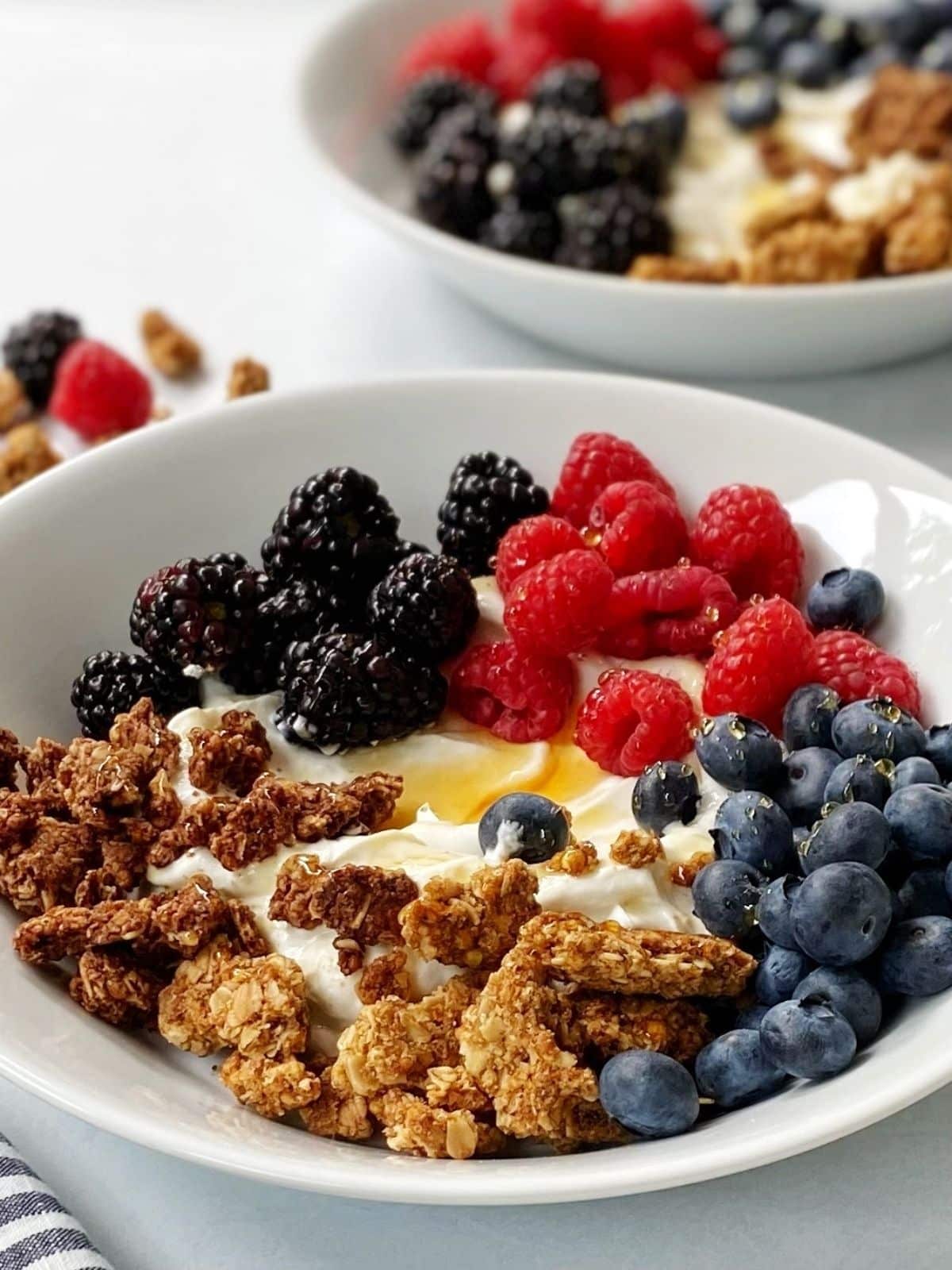 side view close up of bowl of yogurt with granola.