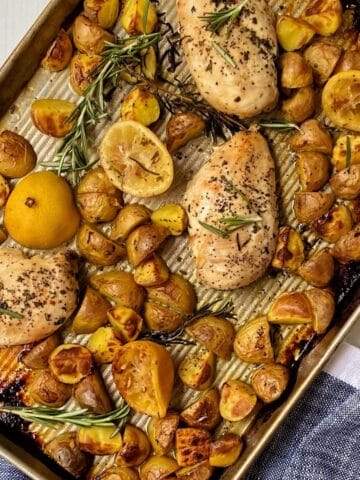 overhead shot of roasted chicken and potatoes on sheet pan.