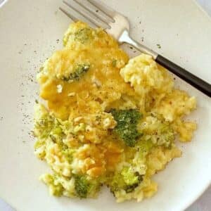close up of broccoli cheese casserole on a plate.