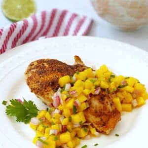 chicken with mango salsa on a white plate.