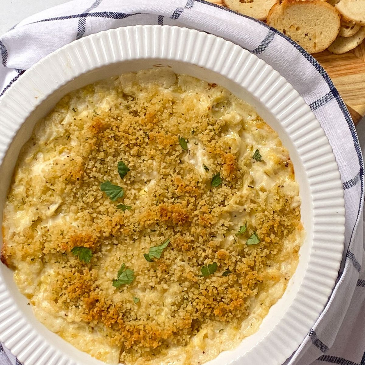 artichoke dip in white serving dish.