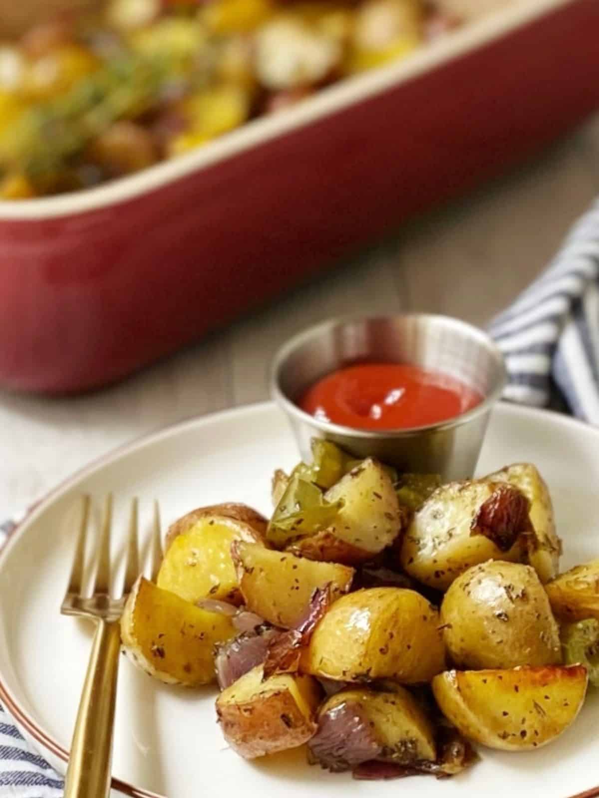 close up of potatoes on a plate with baking dish in background.