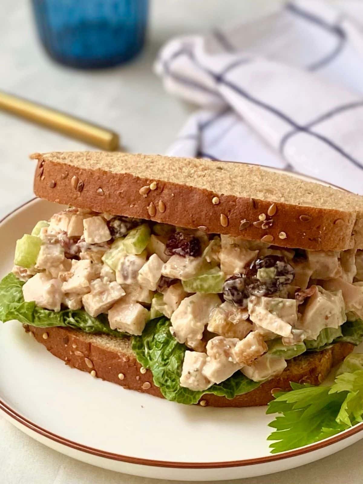 turkey salad on wheat bread on a plate.