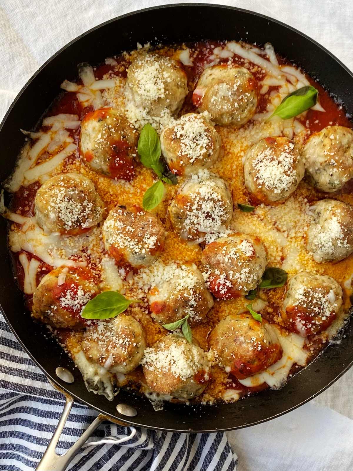 skillet of baked meatballs in sauce.
