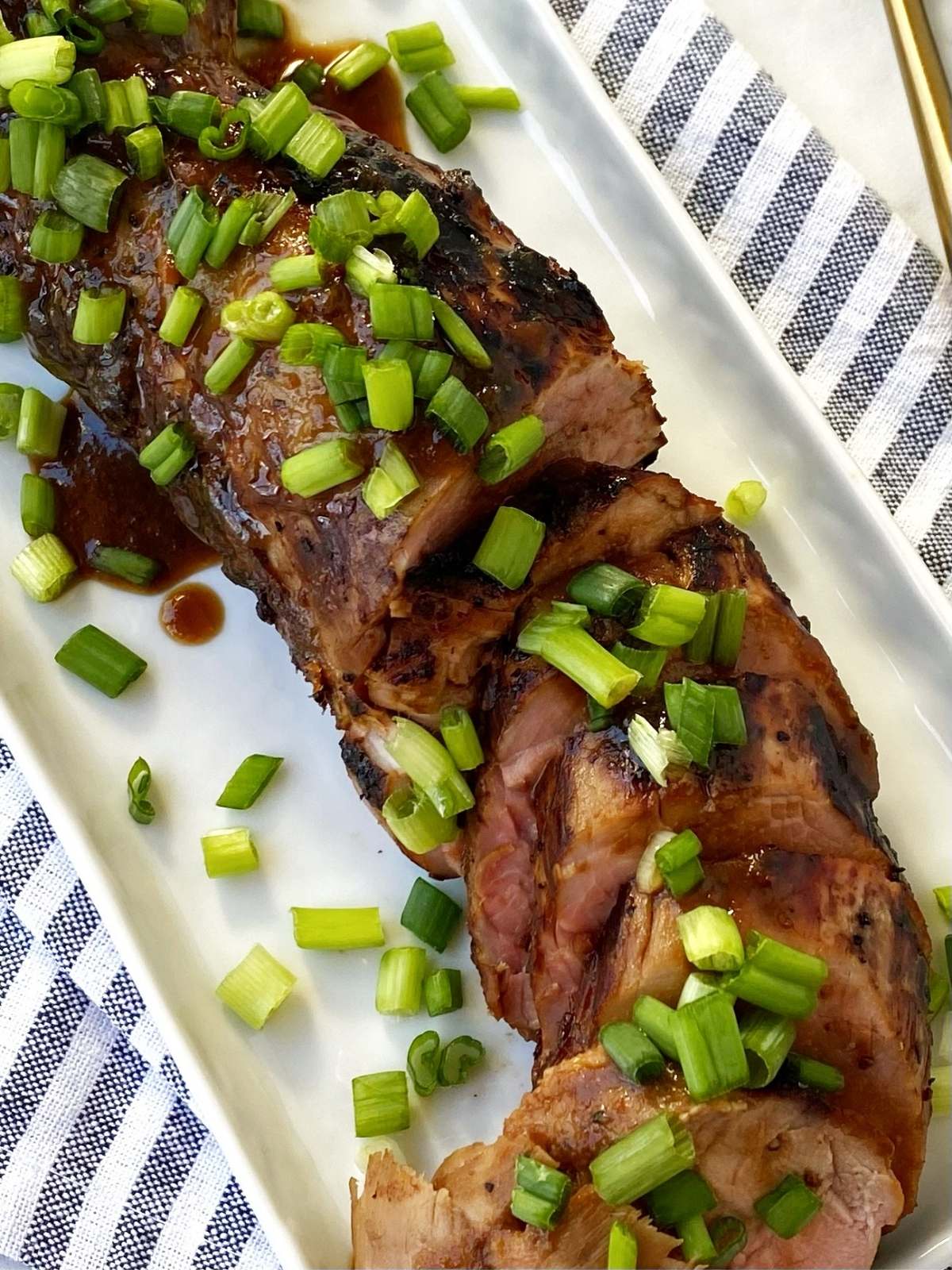 cloe up of sliced pork tenderloin on platter.