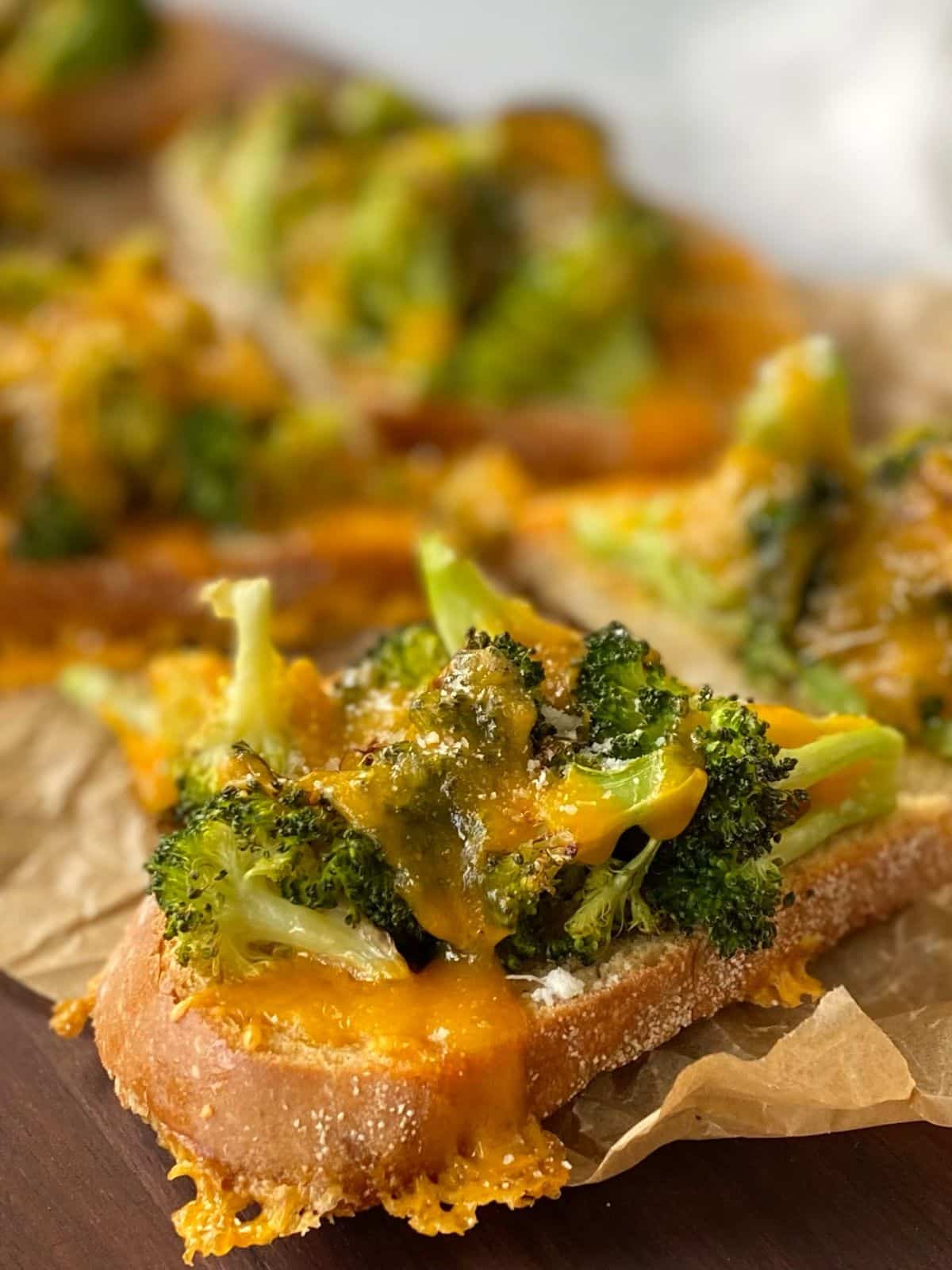 close up of broccoli cheddar toast on a serving board.