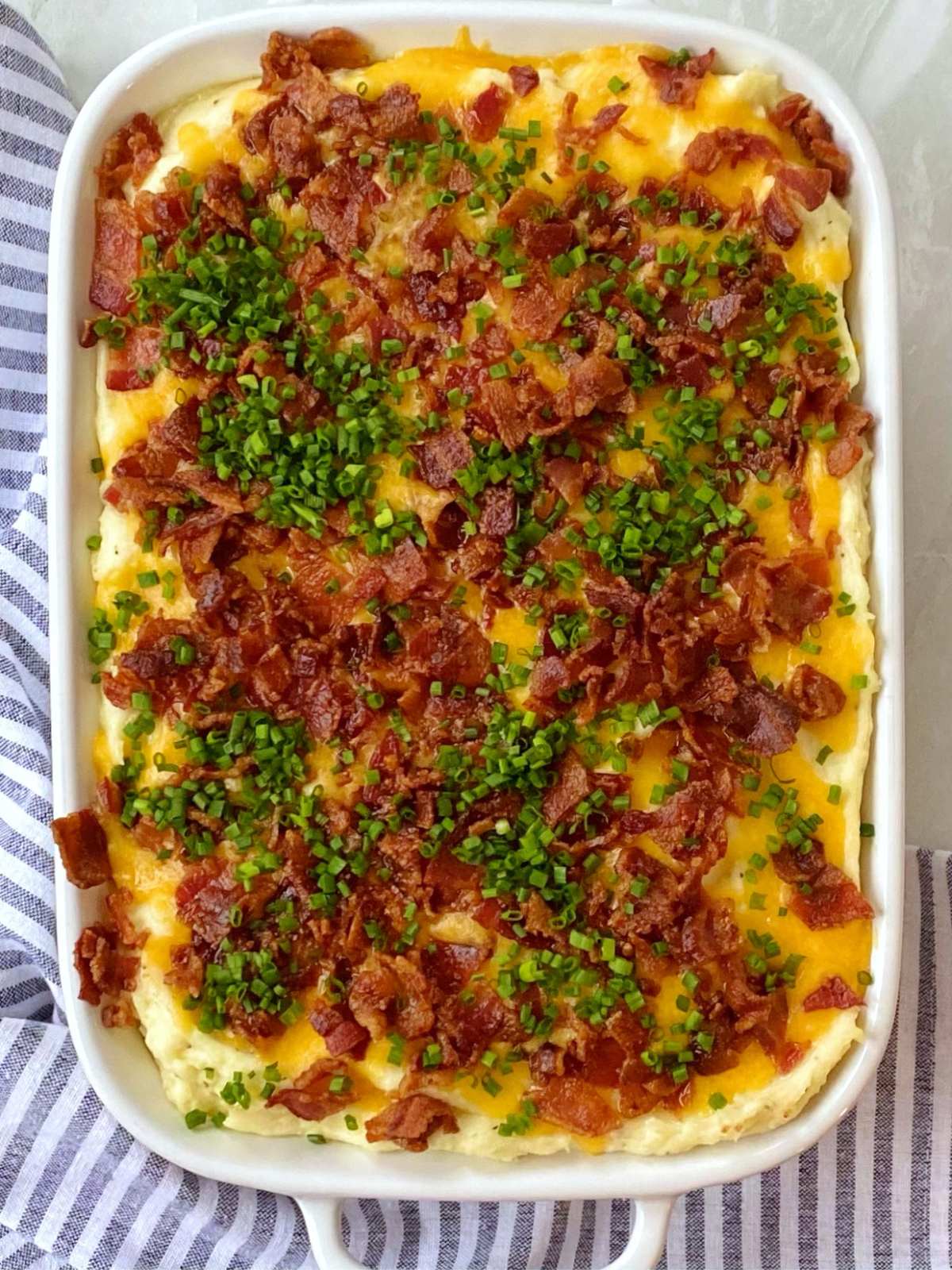 top down shot of baked potato casserole garnished with chives.