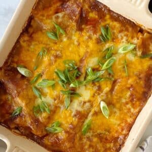 top down shot of chicken enchilada casserole in a square baking dish.