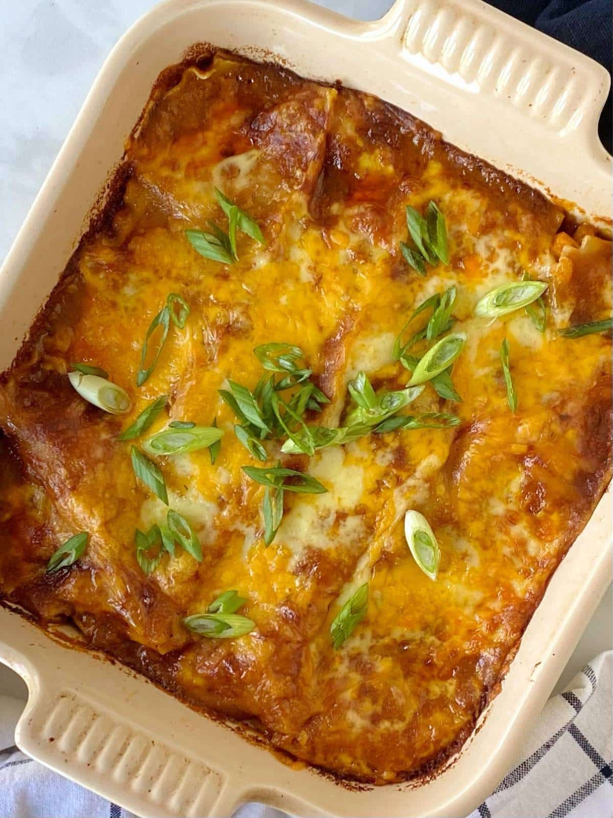 top down shot of chicken enchilada casserole with scallions.