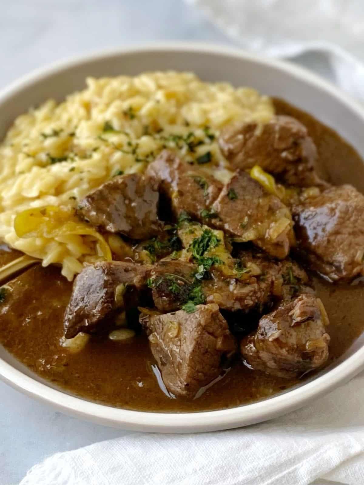 side view of mississippi beef on plate with orzo.
