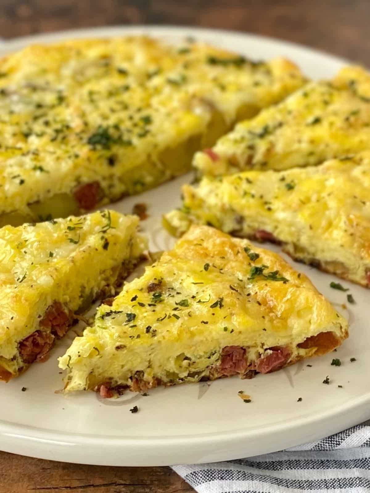 side view of sliced frittata on a platter.