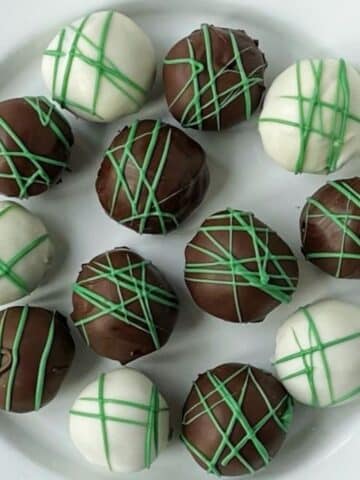 chocolate coated oreo balls on a white plate.