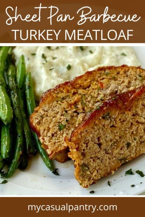 meatloaf on a plate with mashed potatoes and green beans.