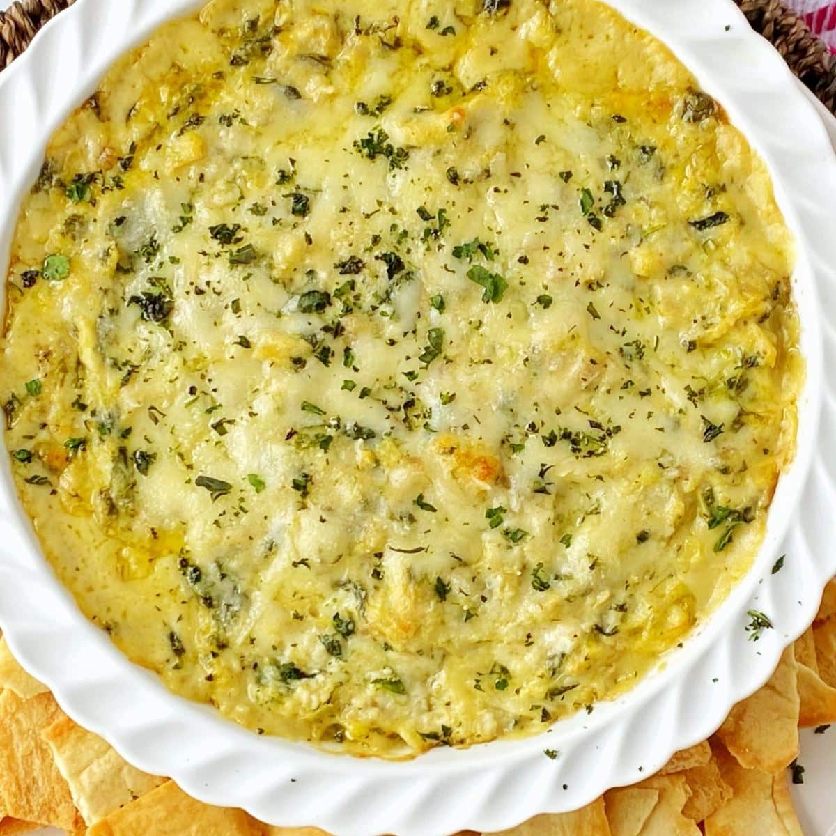 crab spinach artichoke dip in a round white baking dish.