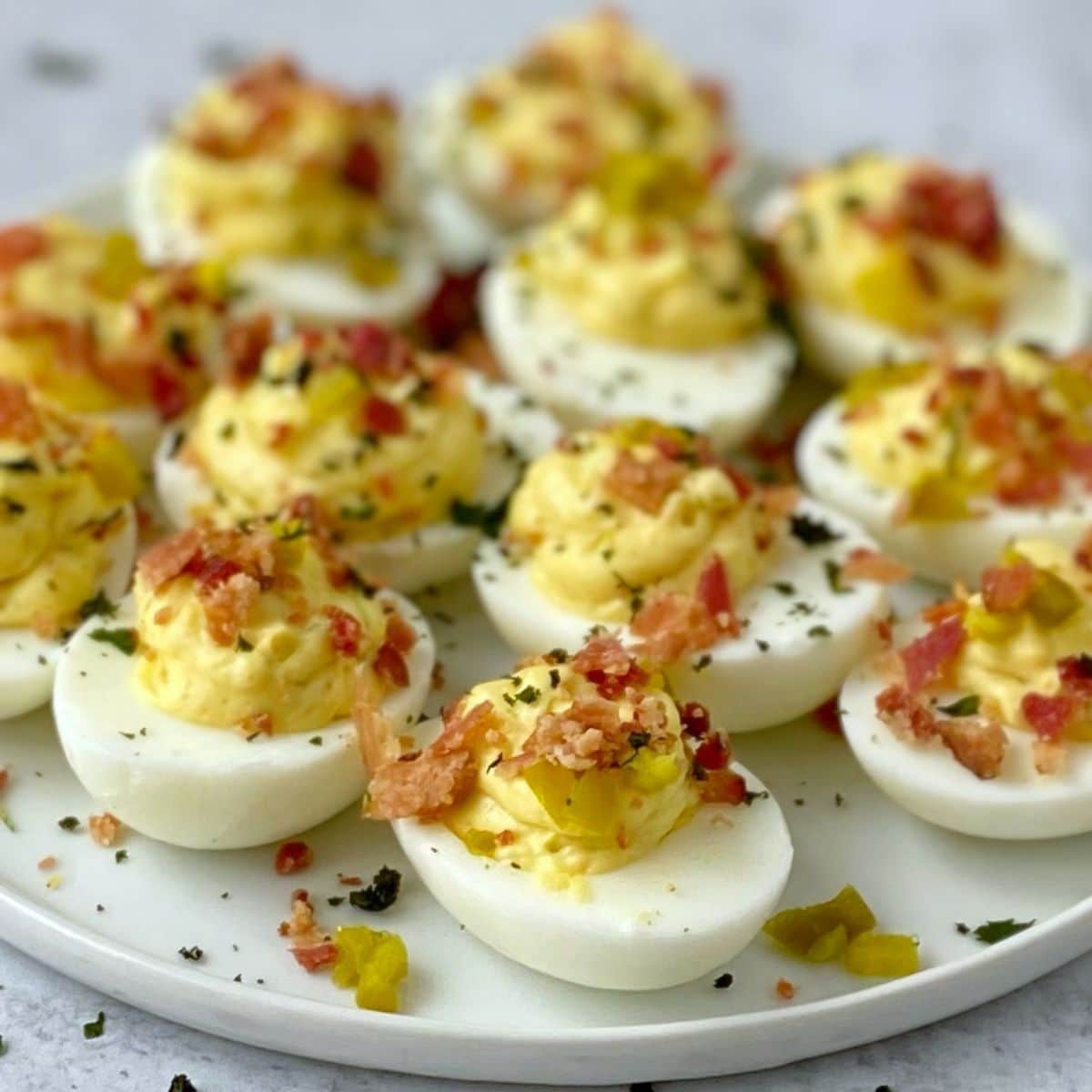 close up of deviled eggs on a white plate.