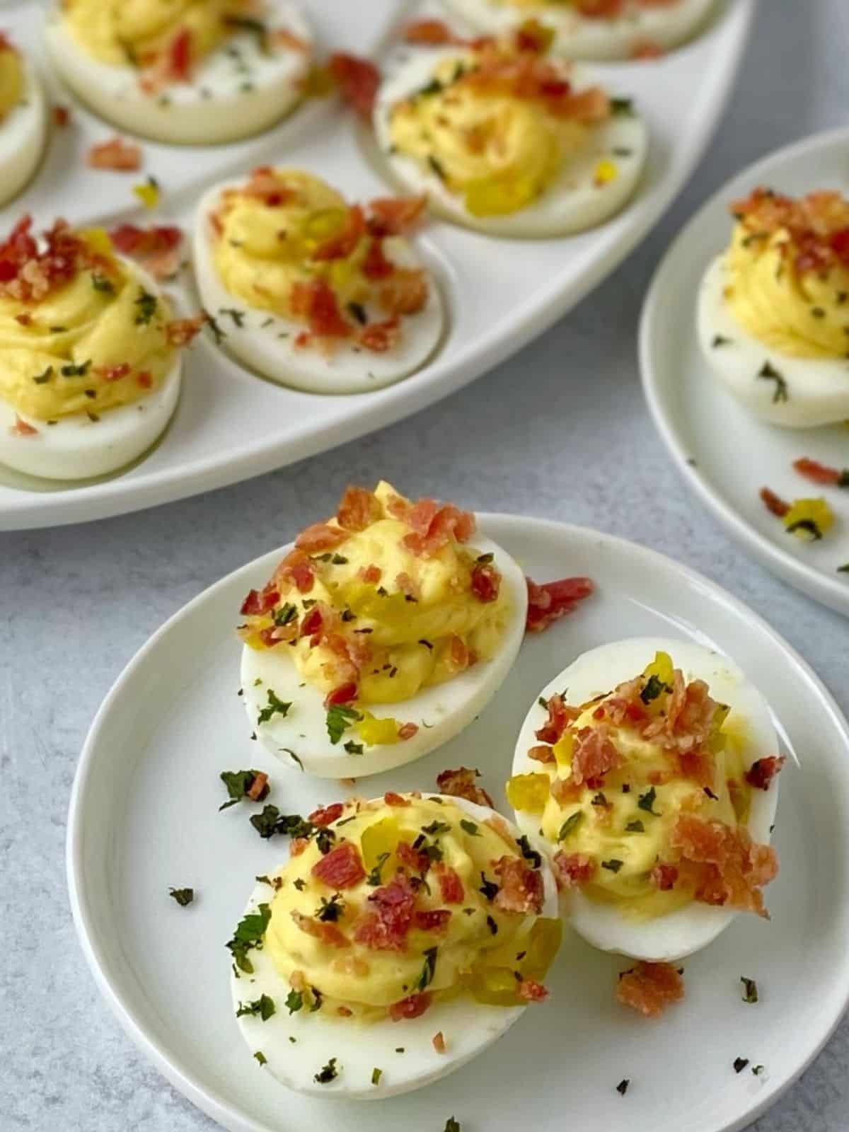 deviled eggs on a platter and plates.
