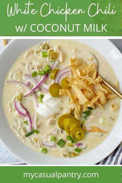 gold spoon in a white bowl of chicken chili with coconut milk.