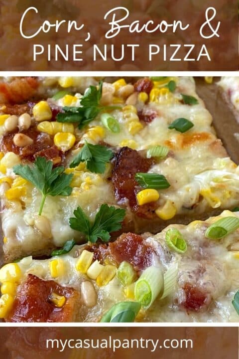 close-up of sliced pizza topped with corn, bacon, and pine nuts.