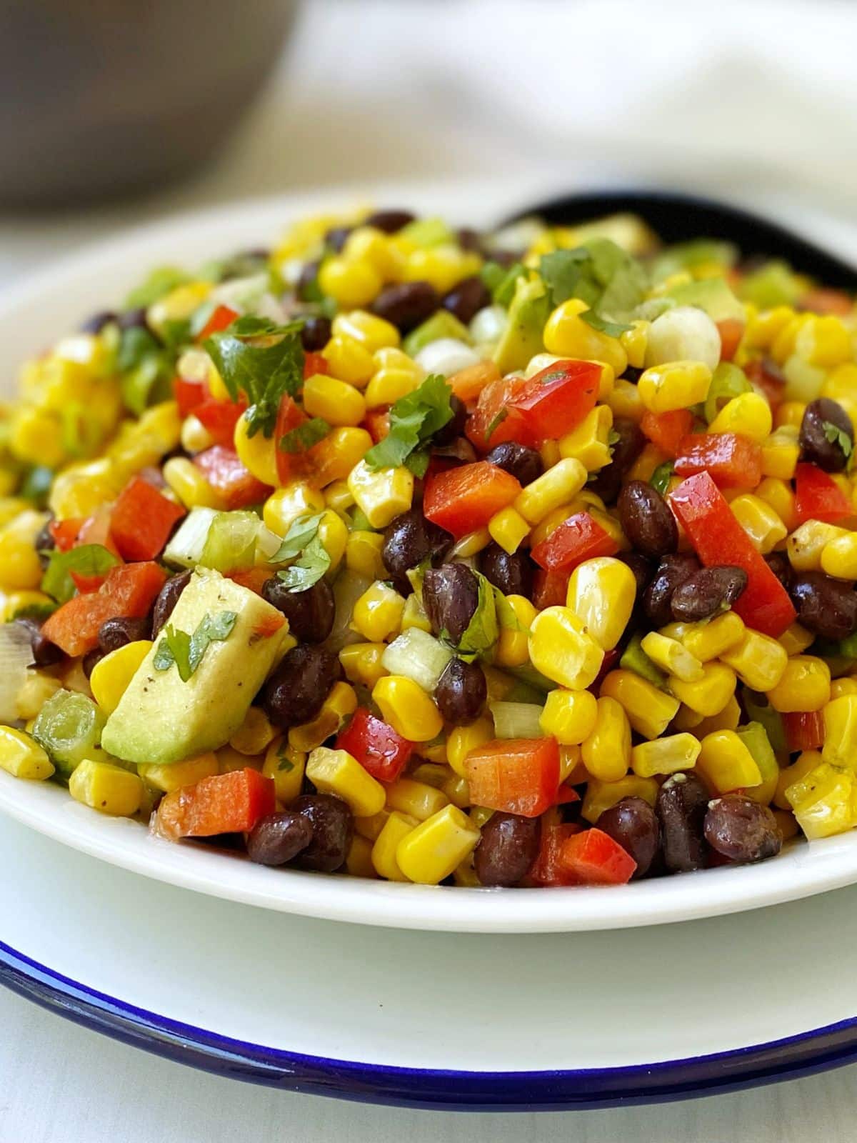 close up of corn and black bean salad in a white bowl.