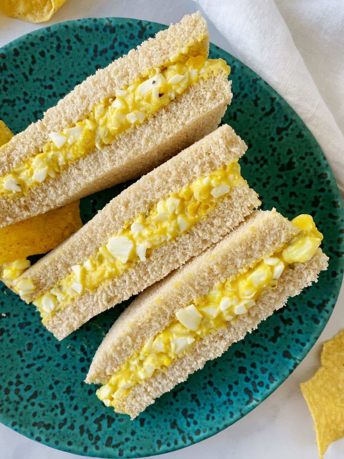 overhead shot of egg salad sandwiches on a plate.