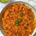 skillet of taco casserole topped with crushed Doritos and garnished with jalapenos.
