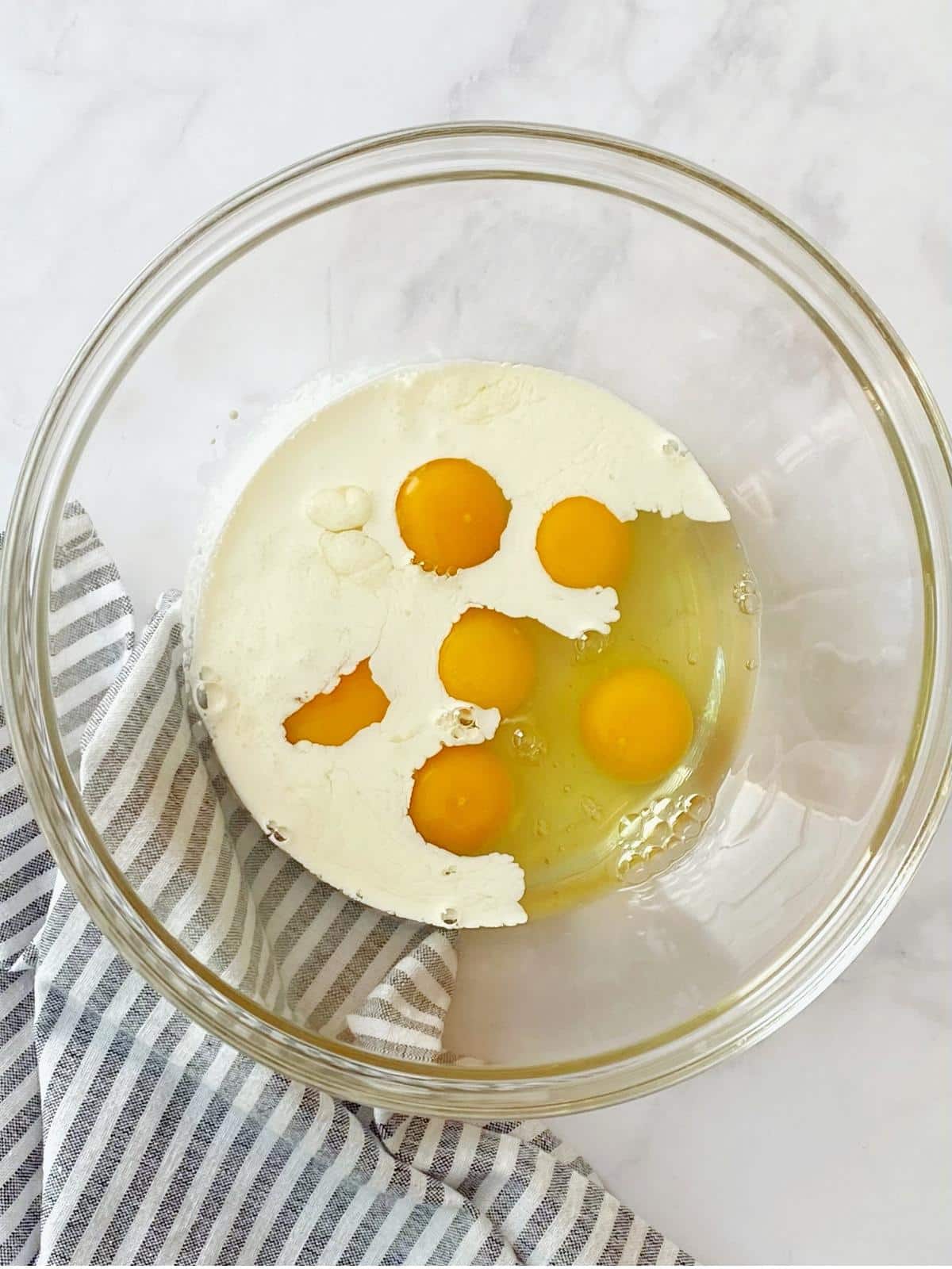 Mixing bowl with eggs and cream.