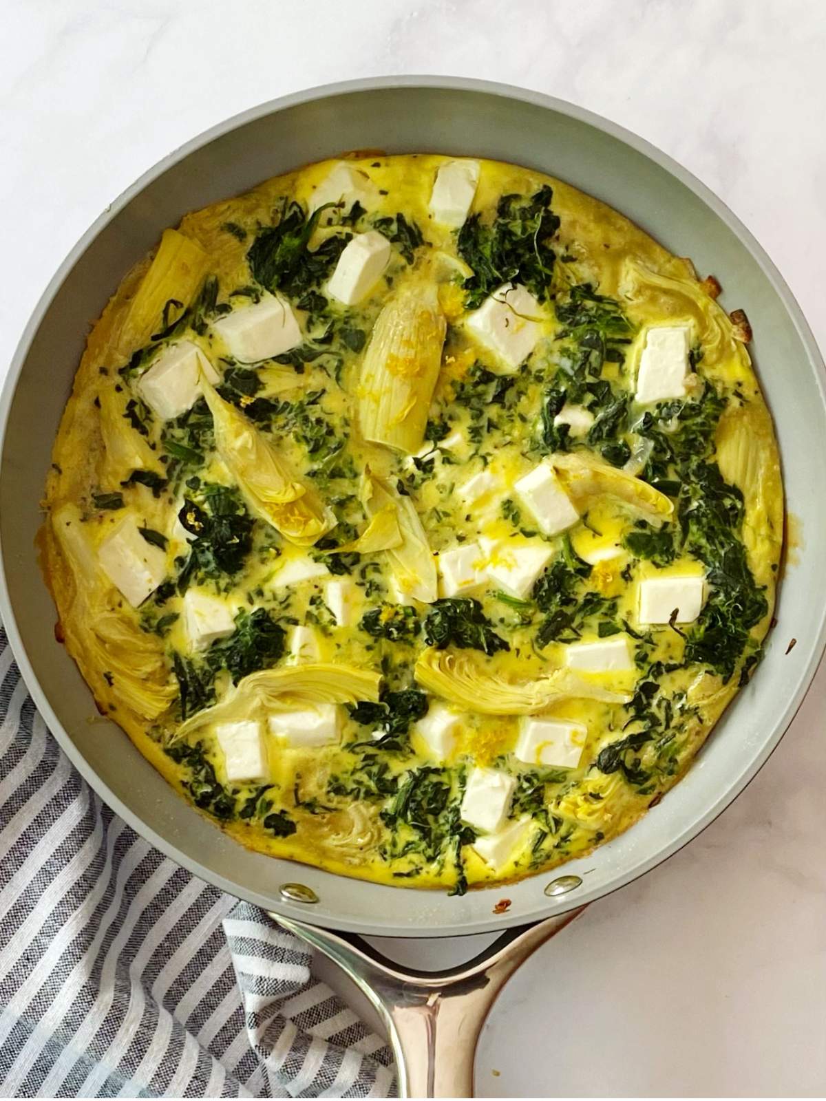 Baked artichoke frittata in a skillet.