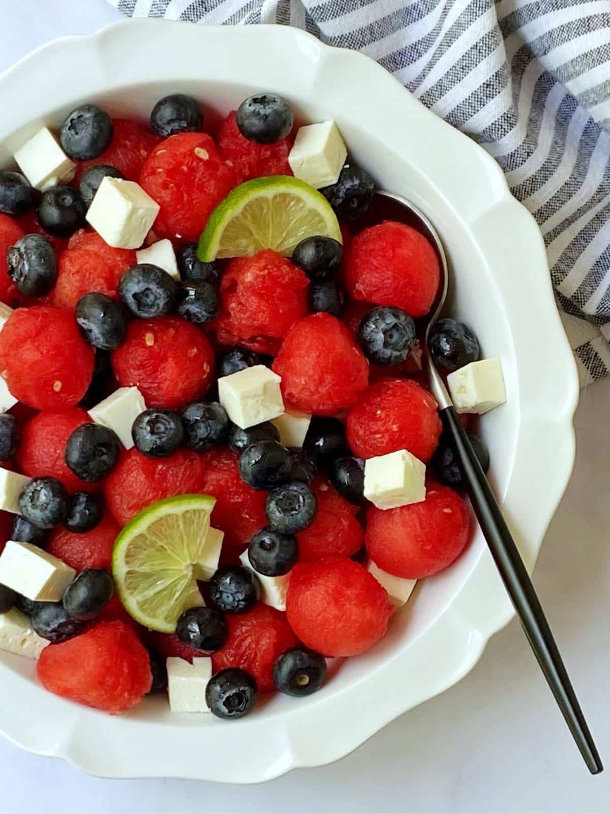 spoon in a dish of watermelon feta salad.