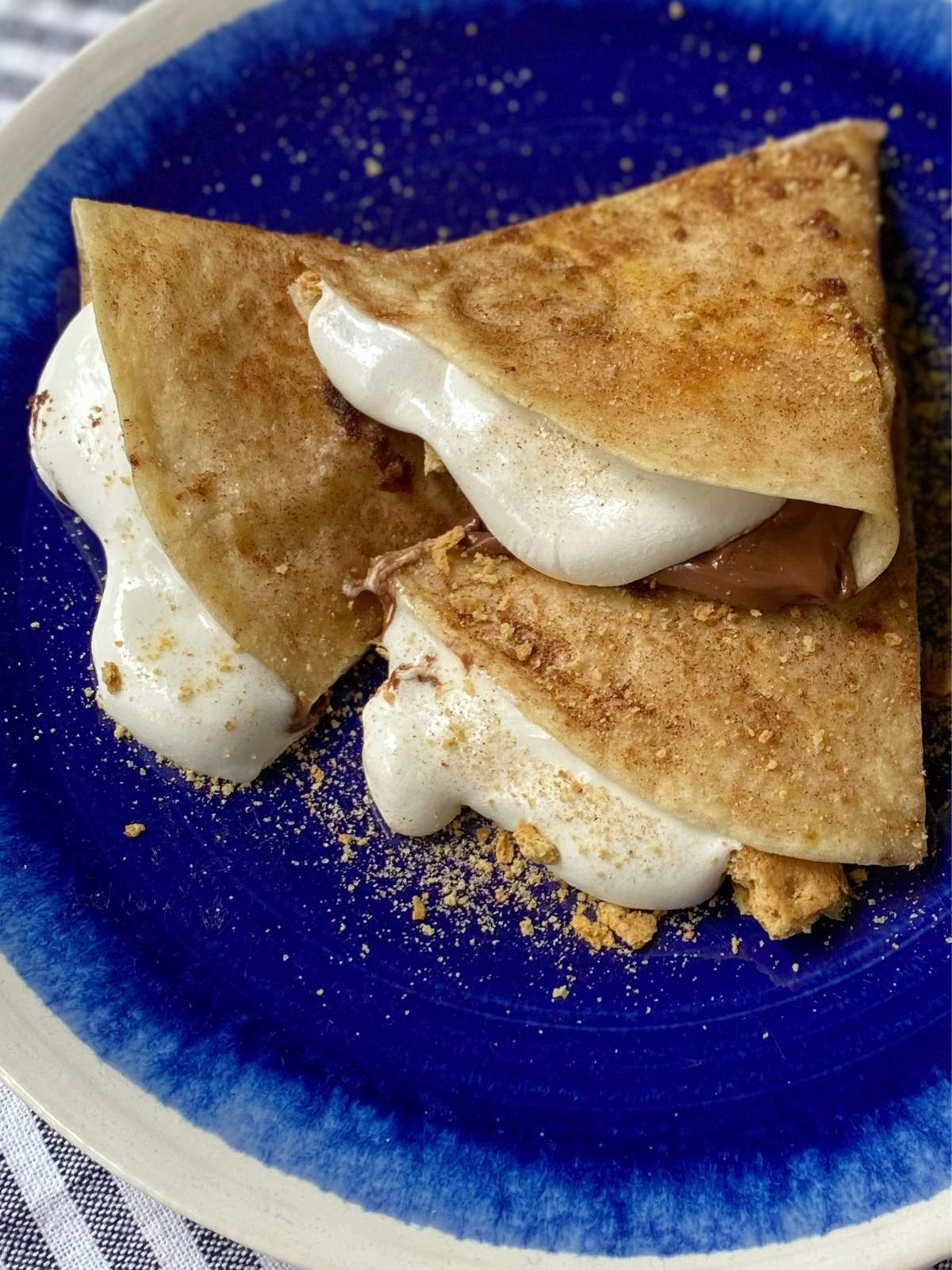 side view of smores quesadilla on a blue plate.