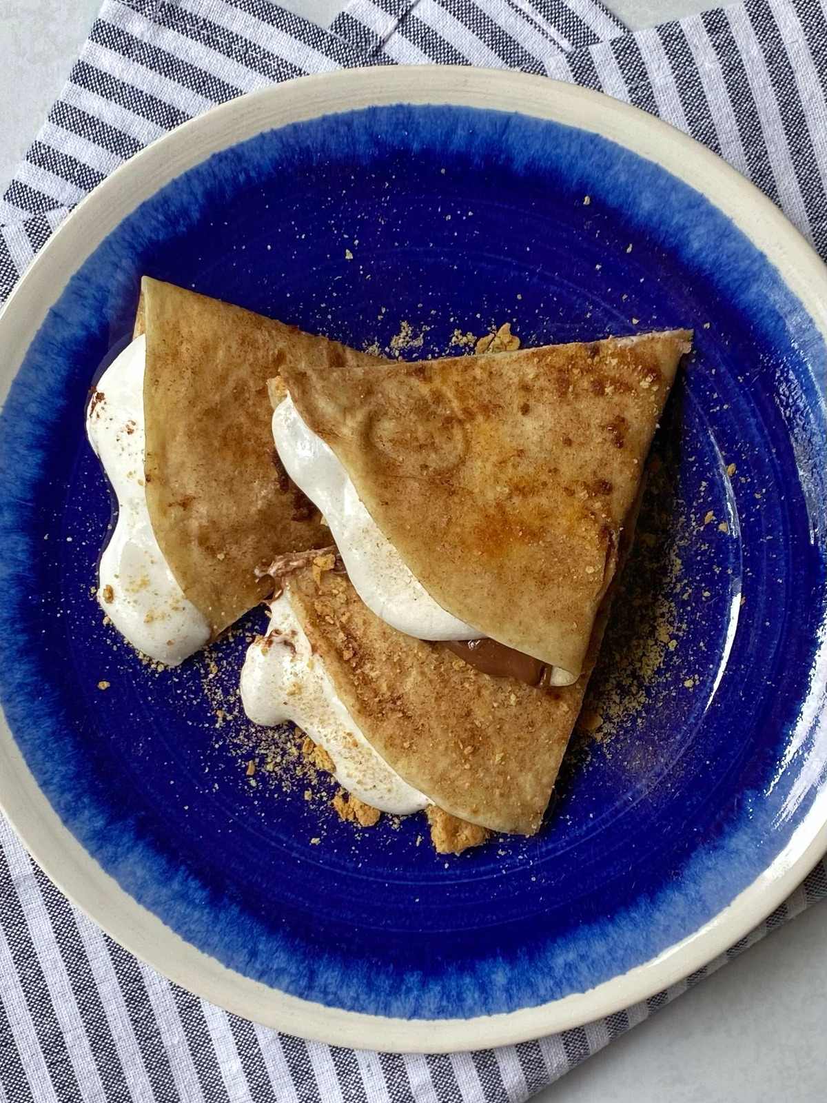 smores quesadilla sliced in wedges on a plate.