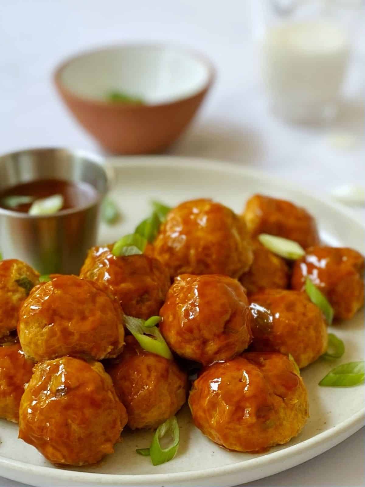 side view of blue cheese buffalo chicken meatballs on a plate.