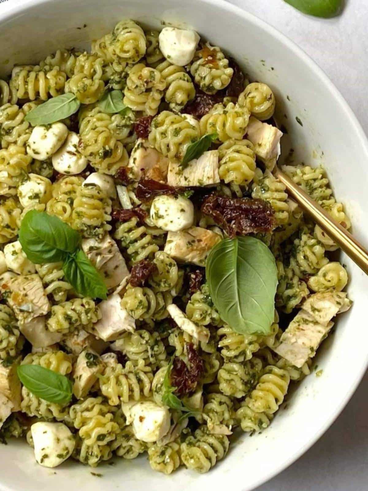 off center bowl of pasta salad with serving spoon.