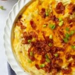 close up of bacon cheddar ranch mashed potatoes in white baking dish.
