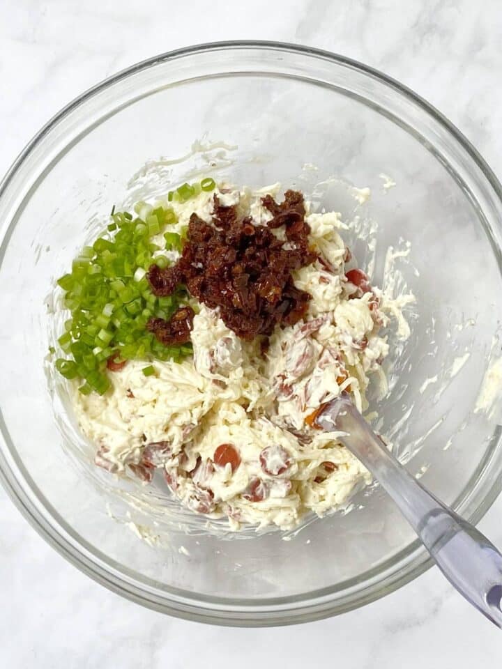 folding scallions and sun-dried tomatoes into cheese mixture.