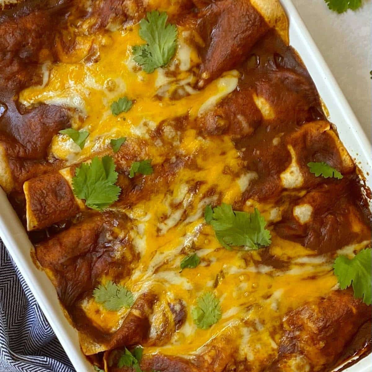 close up of baking dish of ground beef enchiladas.