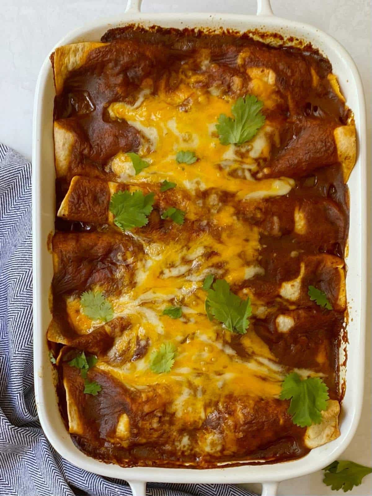 top down shot of baked enchiladas in casserole dish.