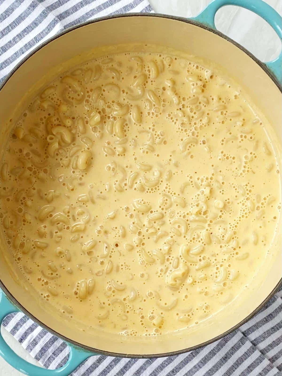 stirring macaroni into cheese sauce.