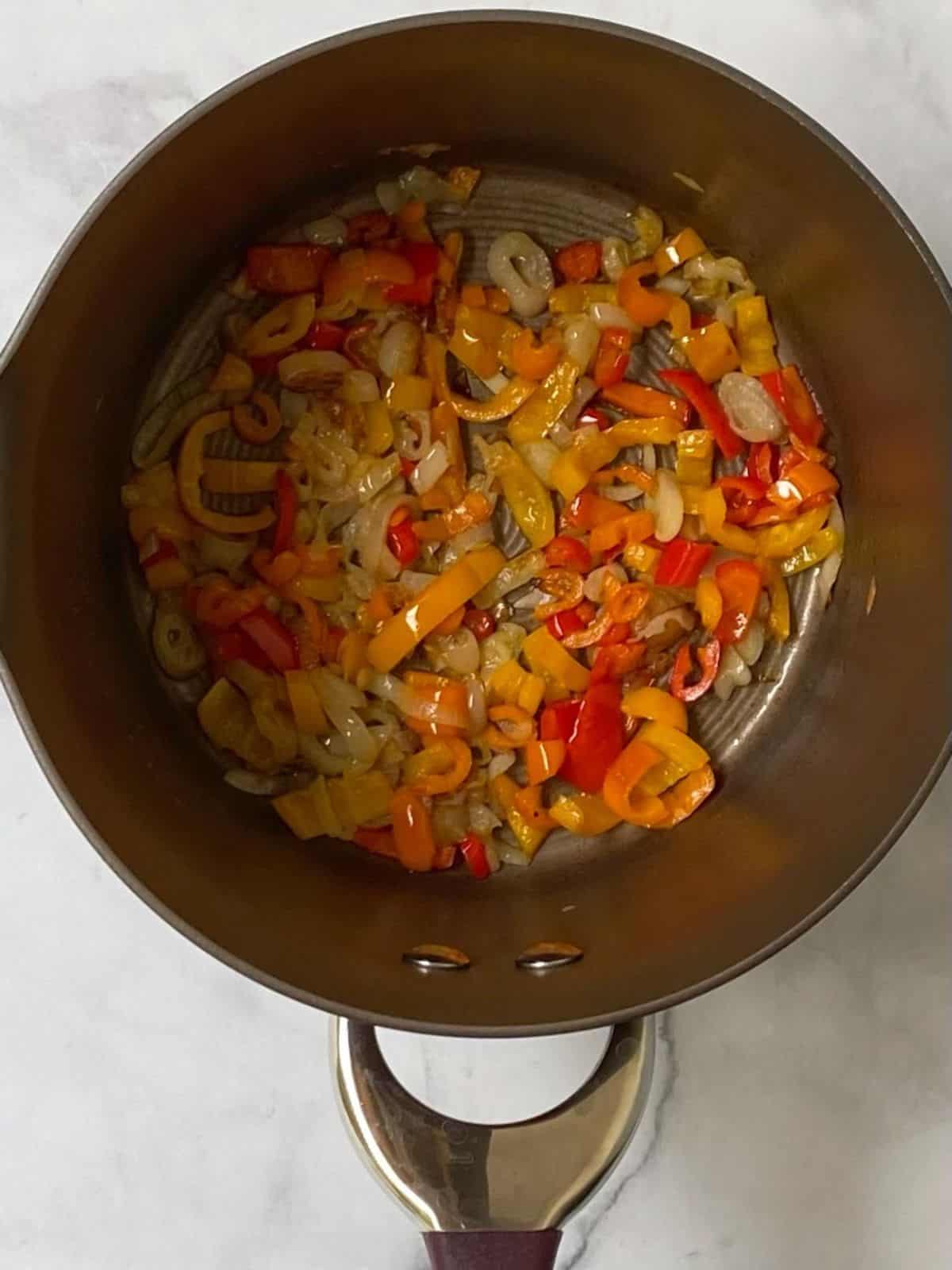 cooking peppers and onions until softened in a saucepan.