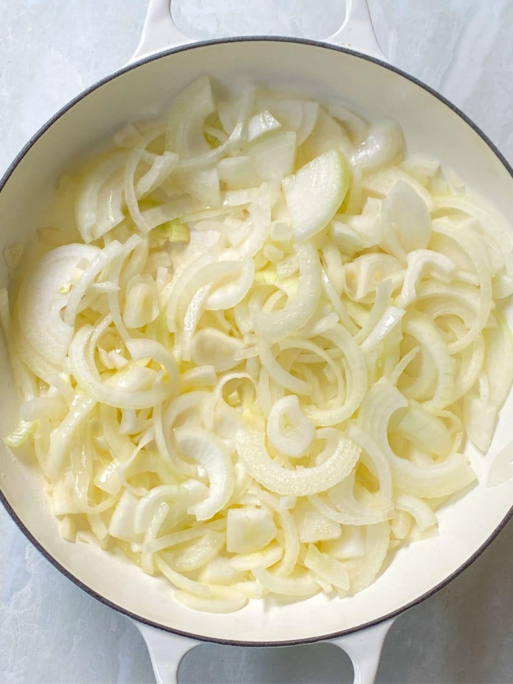 sliced onions added to a skillet.