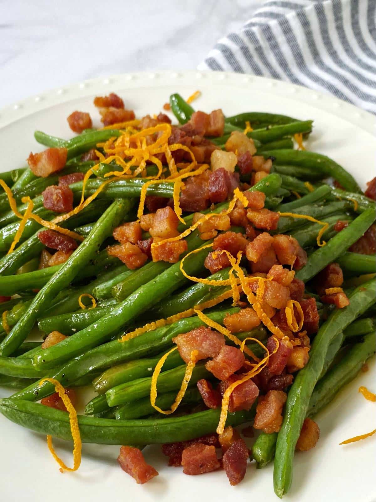 close up of green beans with crispy pancetta and orange butter.