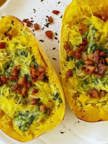 a platter of two spaghetti squash boats with creamed spinach and pancetta.