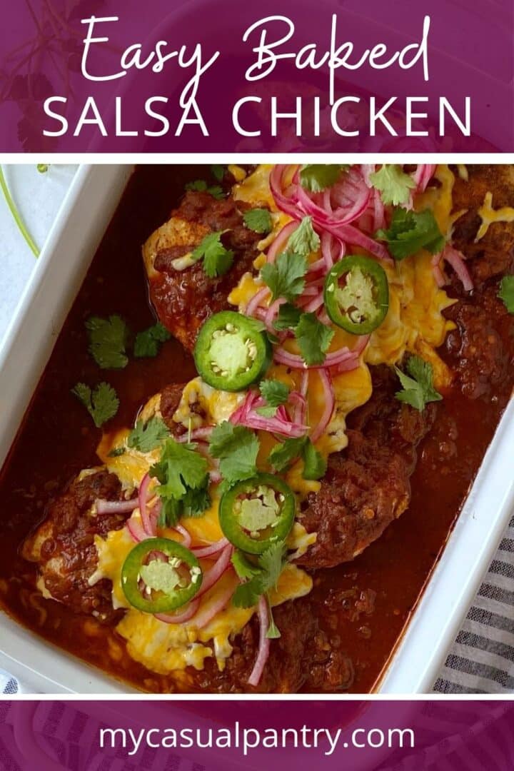 Casserole dish of salsa baked chicken topped with fresh garnishes of cilantro, pickled red onions, and jalapenos.