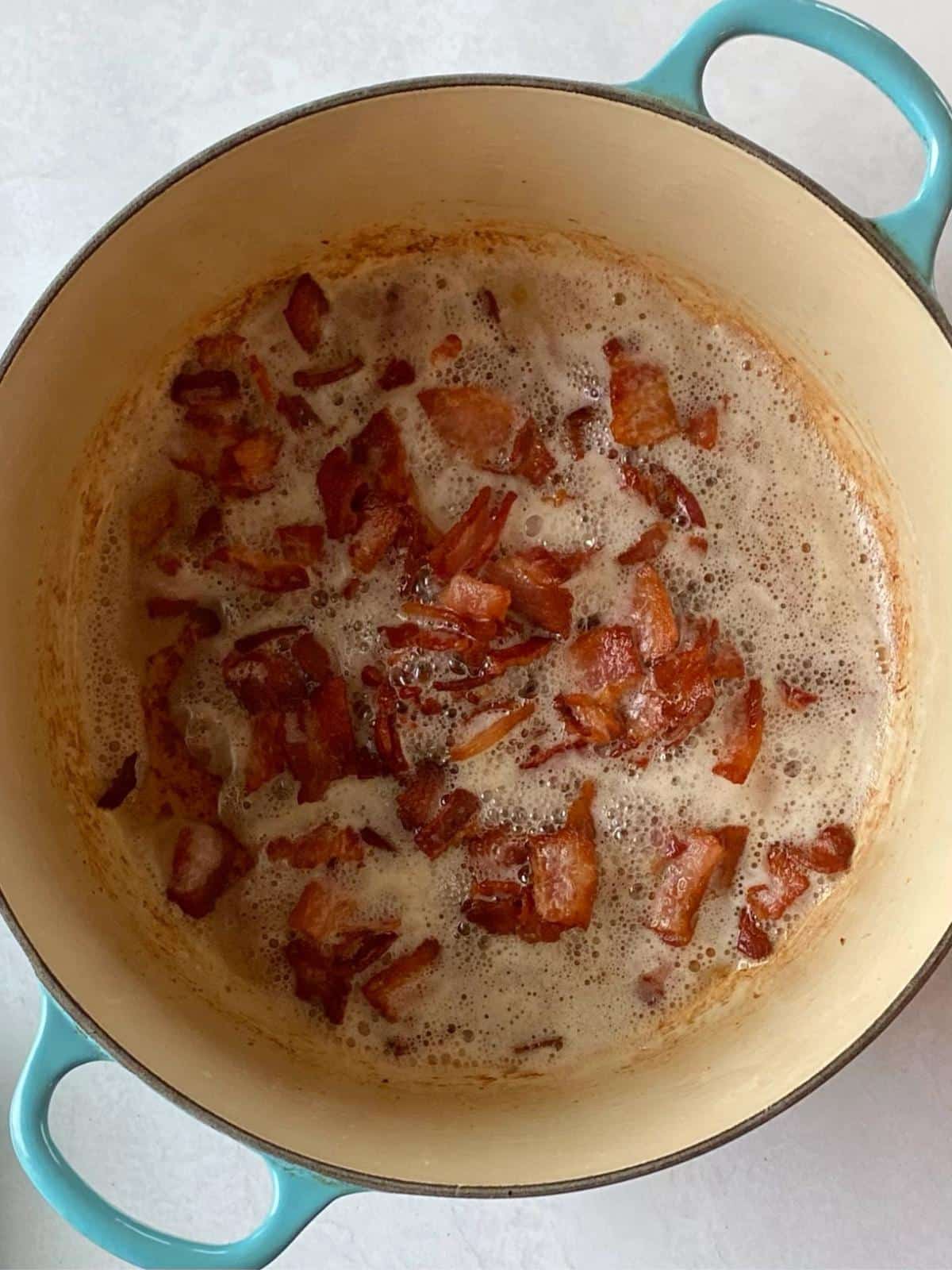 Browning bacon in a Dutch oven.